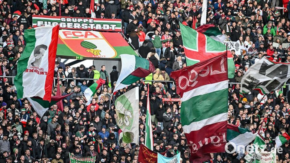 Fans des FC Augsburg schwenken ihre Fahnen in der WWK-Arena. (Archivfoto) Bild: Harry Langer/dpa