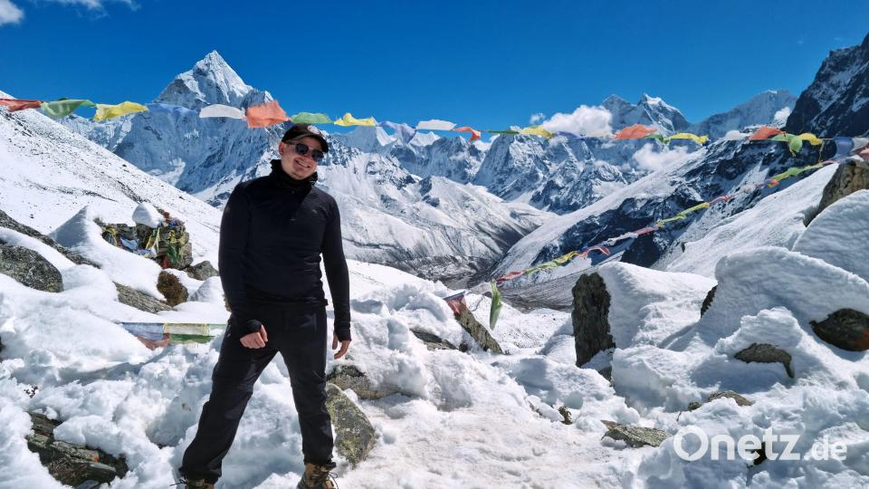 Peter Schröder vor wunderschönem Bergpanorama und Gebetsfahnen im Himalaya. Bild: Archiv Peter Schröder