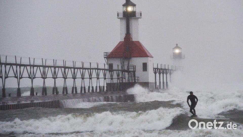 Ein Wellenreiter surft durch wehenden Schnee. Bild: Don Campbell/The Herald-Palladium/AP/dpa