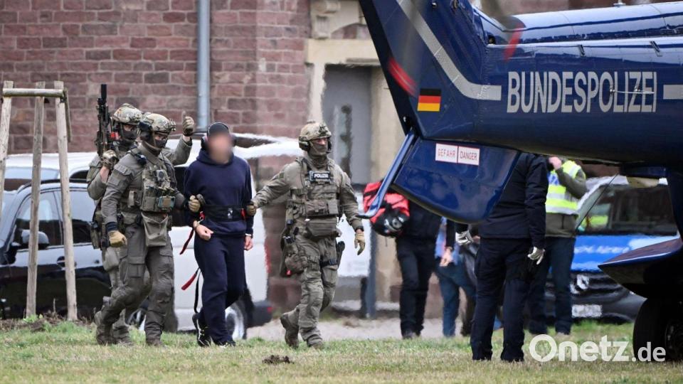 Eine Person wird von Polizeibeamten zu einem Hubschrauber gebracht. Bild: Uli Deck/dpa