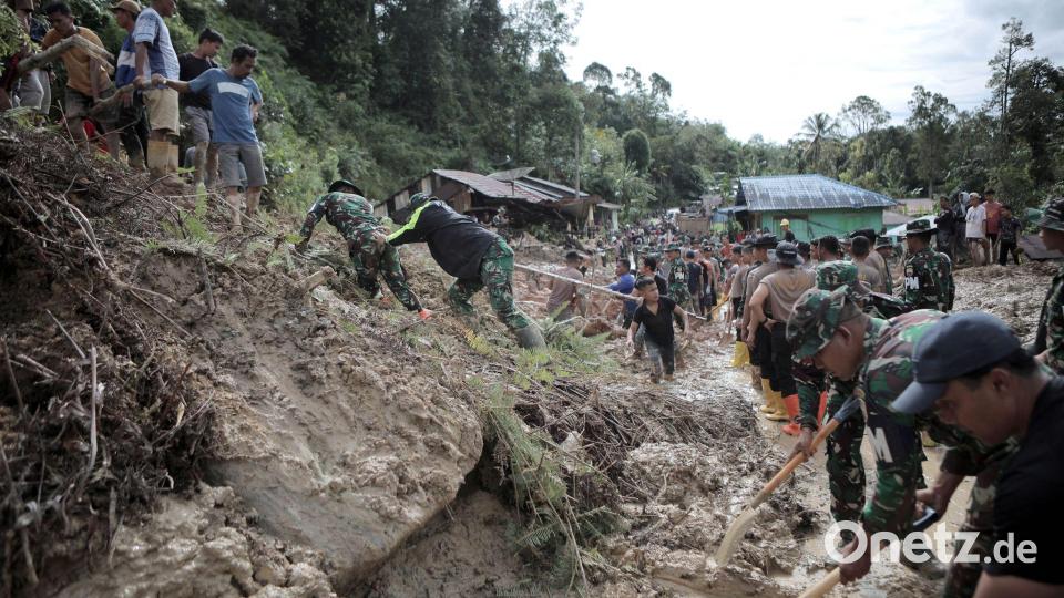 Rettungskräfte und Dorfbewohner beseitigen Schlamm. Bild: Gatha Ginting/XinHua/dpa