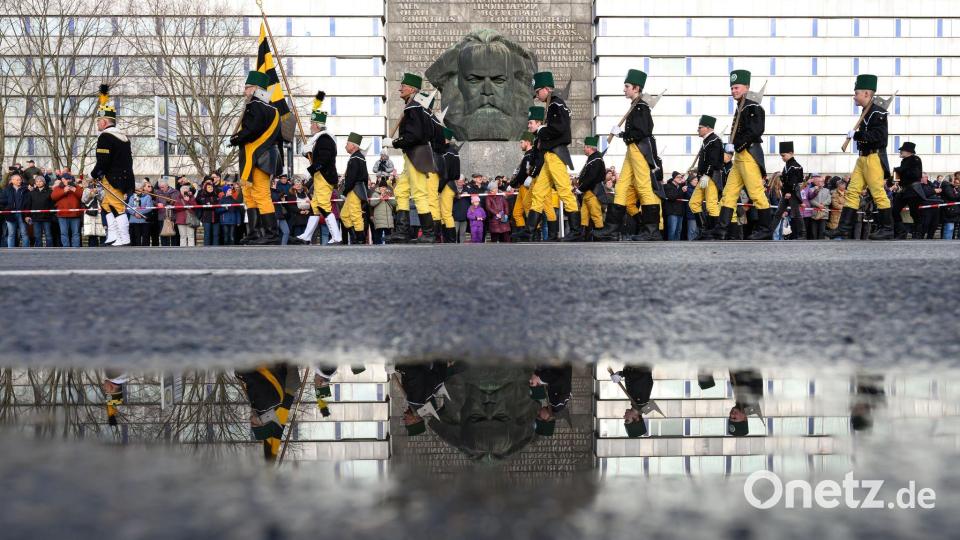 Mehr als 1000 Teilnehmer einer Bergparade ziehen im traditionellen Habit vor dem Karl-Marx-Monument in Chemnitz vorüber. Bild: Hendrik Schmidt/dpa