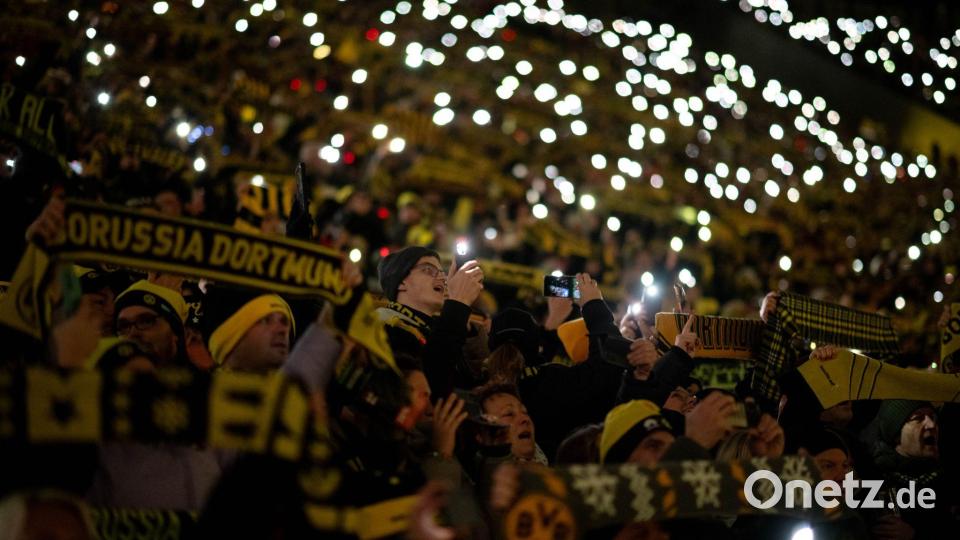 Fans stehen beim traditionellen Weihnachtssingen auf der Süd-Tribüne im BVB-Stadion. Bild: Fabian Strauch/dpa
