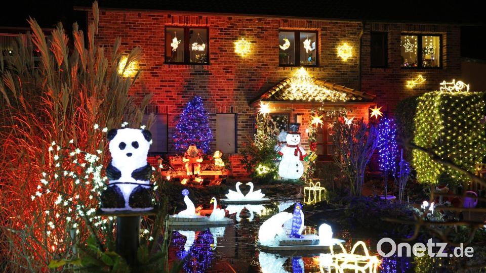 Leuchtende Figuren stehen im Vorgarten umgeben von zahlreichen weiteren Lichtern, die das Weihnachtshaus der Familie Lange erstrahlen lassen. Das Haus wird zur Adventszeit traditionell mit tausenden bunten Lichtern geschmückt. Bild: Matthias Bein/dpa