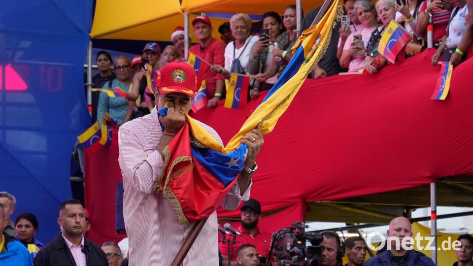 Venezuelas Präsident Nicolas Maduro küsst eine venezolanische Flagge während einer Veranstaltung im Präsidentenpalast in Caracas. Bild: Ariana Cubillos/AP/dpa