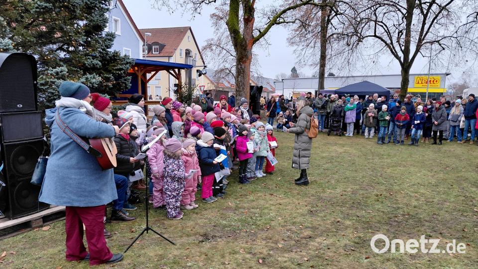 Rings um die Rasenfläche im Park stehen die Zuhörer dicht gedrängt, als der Kinderkirchenchor Weihnachtsweisen anstimmt. Zuvor ist er bereits im Hof der Gaststätte Heining aufgetreten. Bild: Bernhard Piegsa