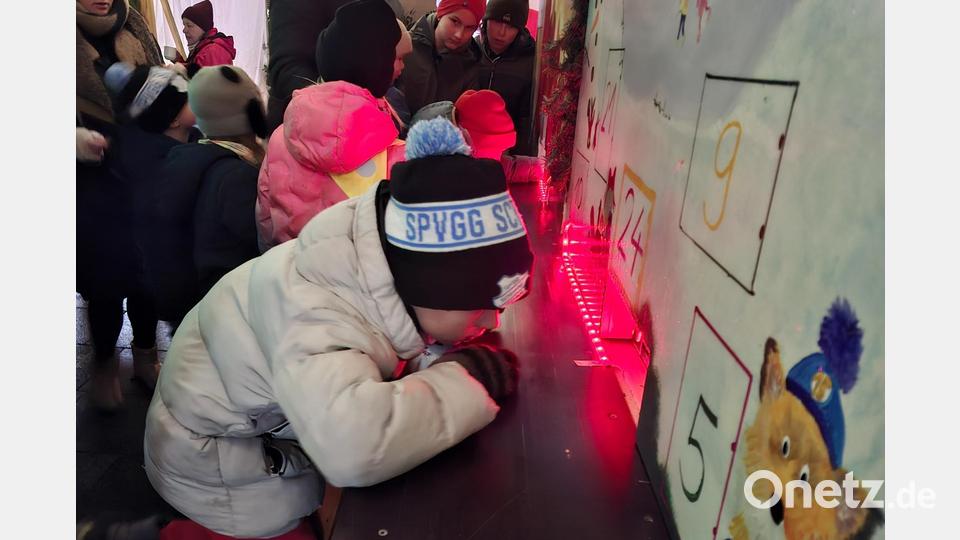 Was sich wohl hinter der beleuchteten Luke verbirgt? Für den geheimnisvollen Adventskalender der Siedler sind vor allem die Kinder Feuer und Flamme. Bild: ise