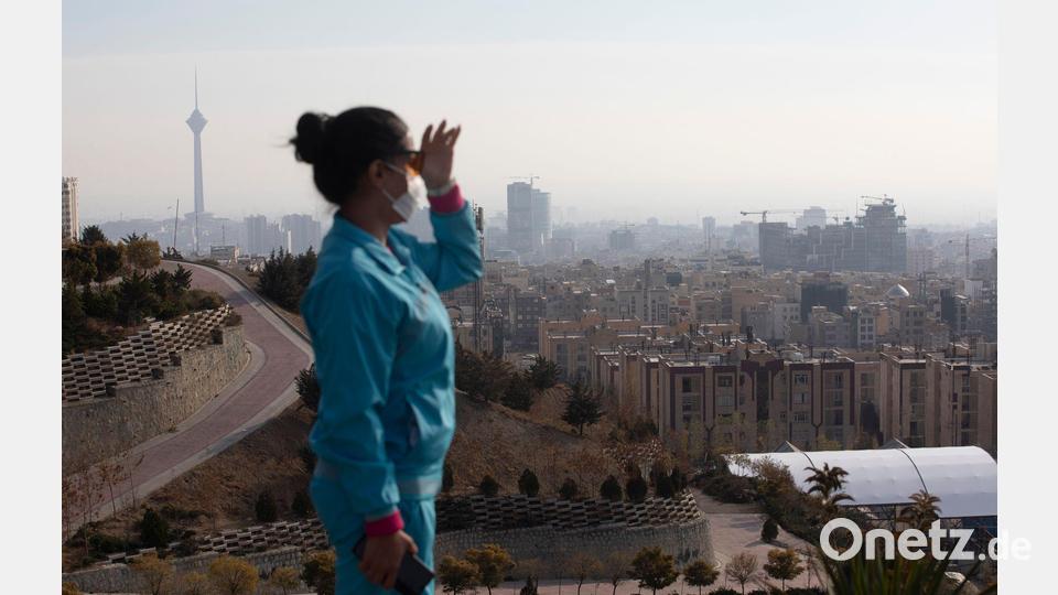 Eine Frau blickt auf die von Smog geplagte Millionenmetropole Teheran. Bild: Aref Taherkenareh/dpa