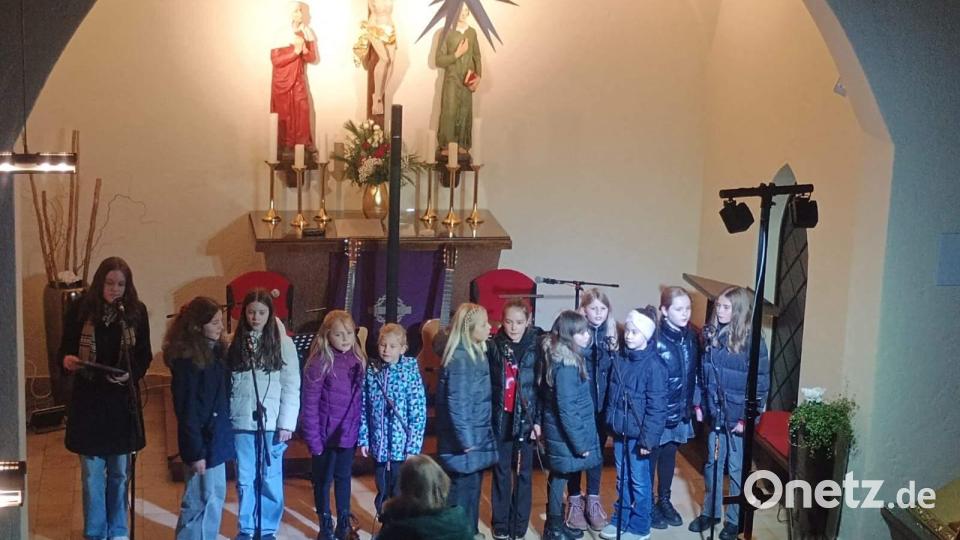 Zu einem emotionalen Höhepunkt der Darbietungen Kinderchors „Herzwärts“ geriet das Duett von Carolina Luber (links) und Magdalena Rauscher (5. von links) „Fang das Licht“. Chorleiterin Gertrud Siegert (vorne) dirigierte. Bild: Nicole Kunze