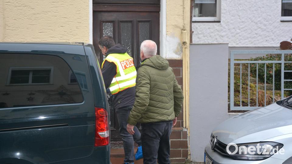 Ein Polizist und ein Ermittler der Kripo Weiden betreten das Haus, in dem sich am Donnerstagvormittag die Tat ereignet hat. Bild: Josef Rosner