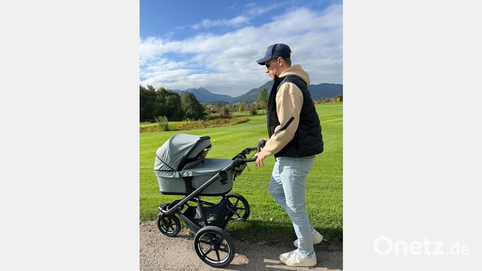 Biathlet Johannes Kühn schiebt seine Tochter im Kinderwagen. Bild: -/Johannes Kühn/dpa