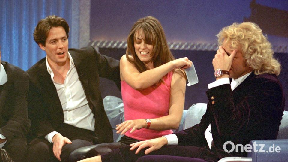 Liz Hurley riss Gottschalk 1999 neben ihrem damaligen Lebensgefährten Hugh Grant mit einer Folie Haar vom Bein. Bild: Patrick Seeger/dpa