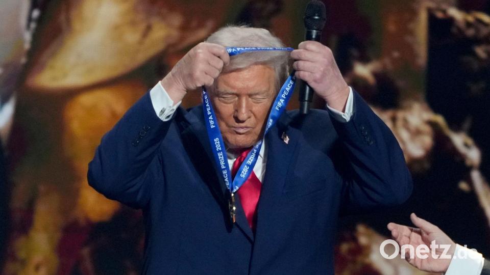 US-Präsident Trump hängt sich die FIFA-Medaille selber um. Bild: Chris Carlson/AP/dpa