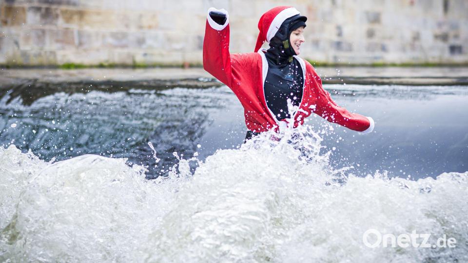 Tine surft als Santa auf der Leinewelle. Bild: Sascha Thelen/dpa