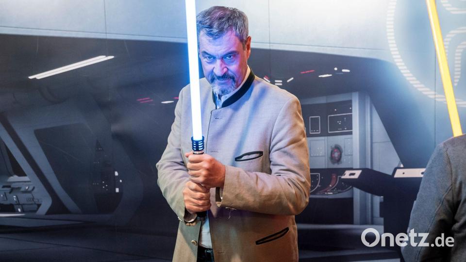 Wohl keine Waffe für den politischen Nahkampf: Markus Söder hält ein Lichtschwert. (Archivbild) Bild: Daniel Vogl/dpa