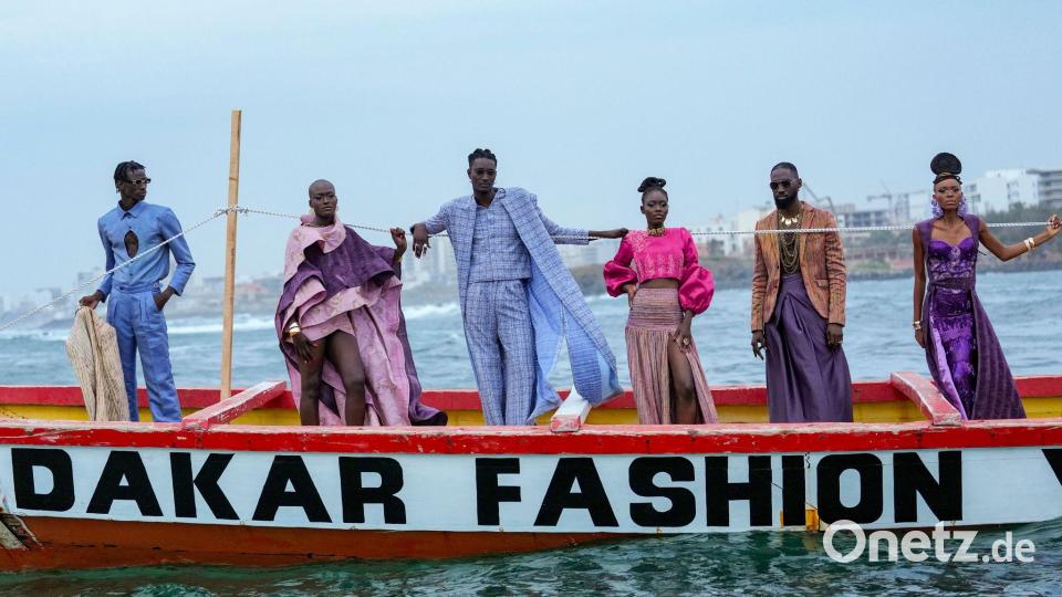 Models präsentieren Kreationen auf einem traditionellen Fischerboot. Bild: Misper Apawu/AP/dpa