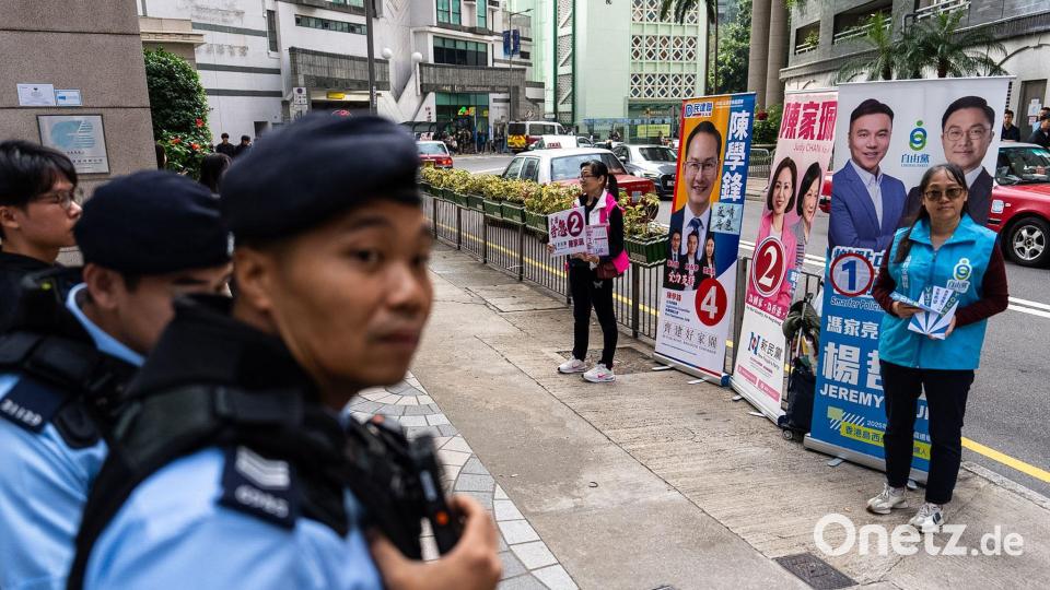 Polizeibeamte stehen Wache, während einer Wahlkampfveranstaltung. Bild: Chan Long Hei/AP/dpa