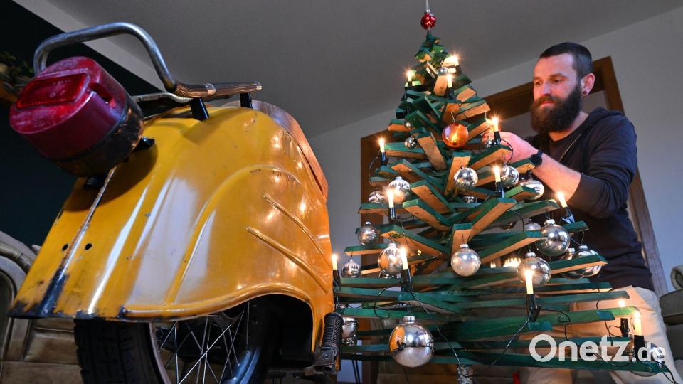 Jan Hofmann schmückt einen Weihnachtsbaum auch mit Weihnachtsbaumkugeln aus Simson-Blinkern. Bild: Martin Schutt/dpa