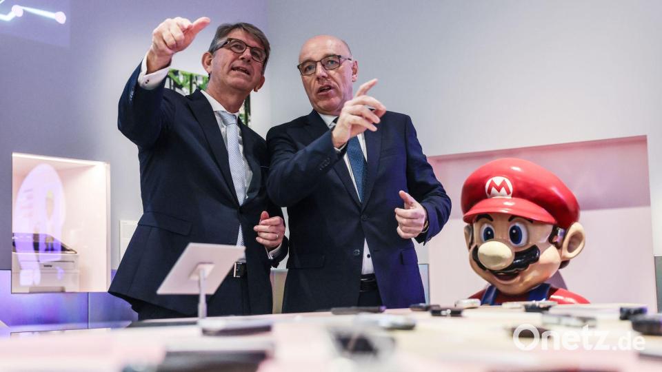 Nicht nur Kulturstaatsminister Wolfram Weimer und der Präsident der Stiftung Haus der Geschichte, Harald Biermann, können nun rätseln, welche Handy sie noch kennen. Bild: Oliver Berg/dpa