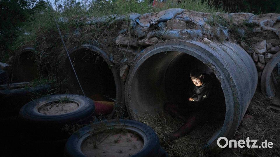 Ein thailändischer Einwohner, der vor Zusammenstößen zwischen thailändischen und kambodschanischen Soldaten geflohen ist, benutzt sein Mobiltelefon, während er in der thailändischen Provinz Buriram Schutz sucht. Bild: Wason Wanichakorn/AP/dpa