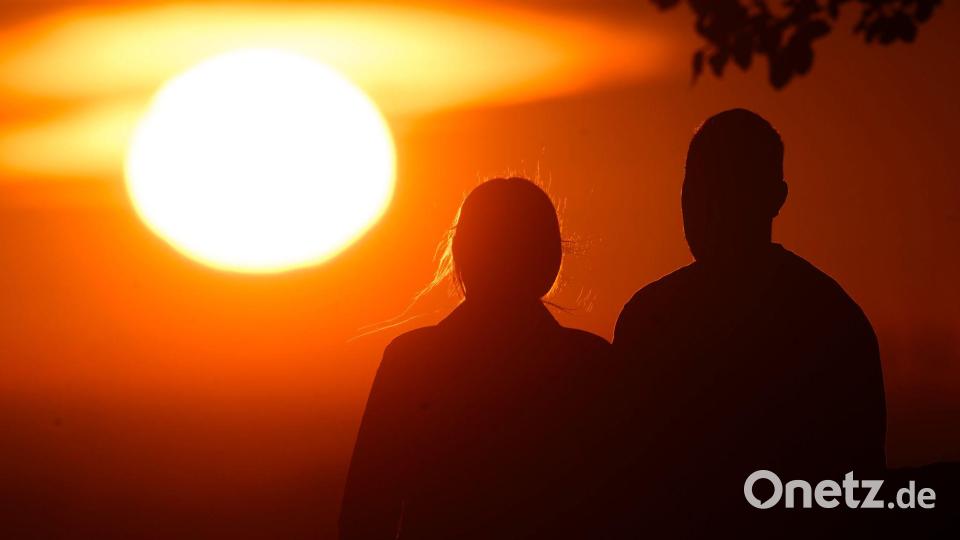 Ein Paar bei Sonnenaufgang Bild: Julian Stratenschulte/dpa