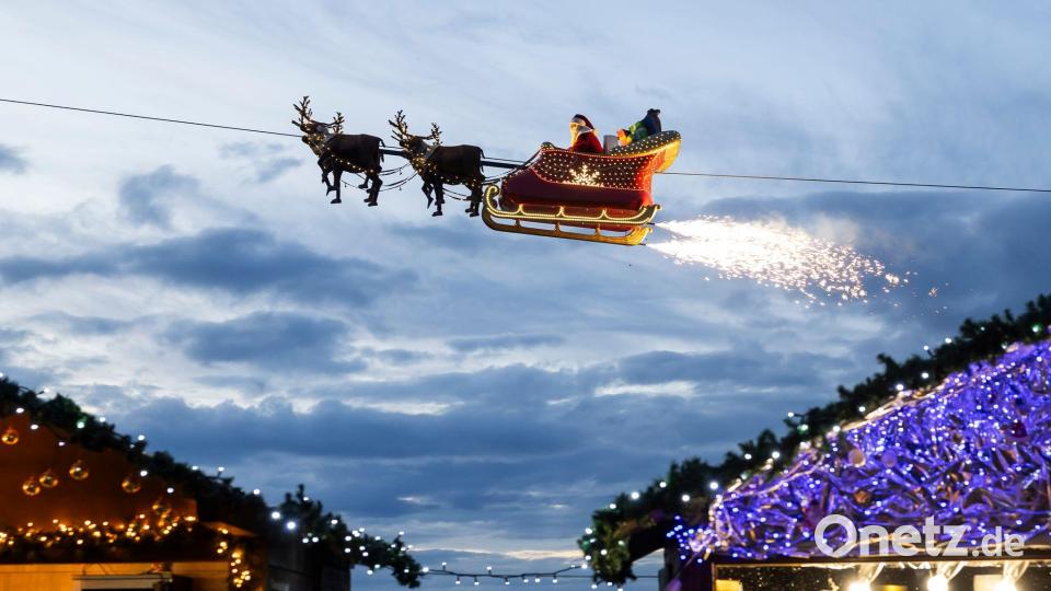 Ein Weihnachtsmann in einem fliegenden Schlitten ist in Montreux über den Weihnachtsständen vom Weihnachtsmarkt unterwegs. Bild: Cyril Zingaro/KEYSTONE/dpa
