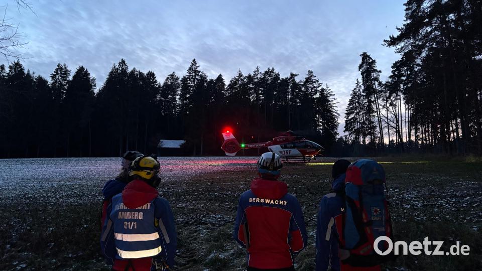 Einsatzkräfte der Bergwacht Amberg am Landeplatz. Christoph 27 hebt im Sonnenuntergang ab. Bild: Bergwacht Amberg