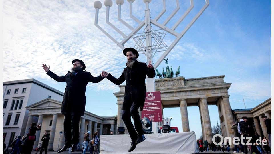 Yehuda Teichtal (l), orthodoxer Rabbiner, und Rabbi Shmuel Segal tanzen bei der Einweihung des Chanukka-Leuchters am Brandenburger Tor in Berlin. Bild: Kay Nietfeld/dpa
