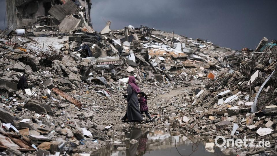 Palästinenser gehen bei stürmischem Wetter durch die Trümmer in Gaza. Bild: Jehad Alshrafi/AP/dpa