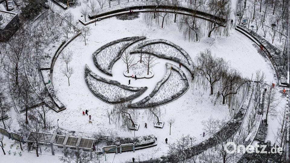 Menschen haben Spaß im Schnee in einem Park in Peking. Bild: Chen Yehua/XinHua/dpa