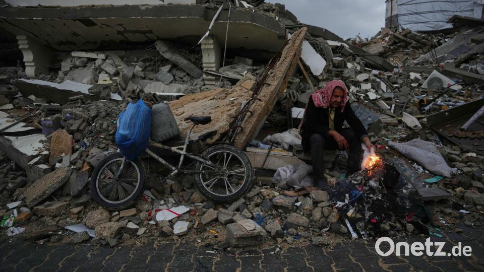 Der Palästinenser Mohammed al-Jabri, 58, wärmt sich neben einem Feuer, während er auf den Trümmern eines Gebäudes sitzt, das während der israelischen Luft- und Bodenoperationen im Viertel Sheikh Radwan zerstört wurden. Bild: Abdel Kareem Hana/AP/dpa