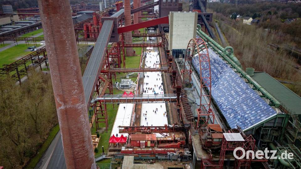 Menschen tummeln sich auf der Eisbahn in der Zeche Zollverein in Essen. Bild: Henning Kaiser/dpa