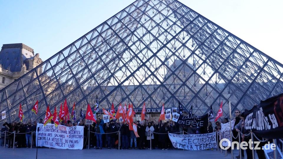 Angestellte vor der Glaspyramide im Louvre, nachdem sie für einen Streik gestimmt haben. Bild: Michel Euler/AP/dpa