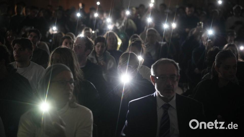 Während der Feierlichkeiten zum jüdischen Chanukka-Fest in Jerusalem leuchten Menschen mit ihren Smartphones zum Gedenken an die Toten am Bondi Beach in Sydney, Australien. Bild: Leo Correa/AP/dpa