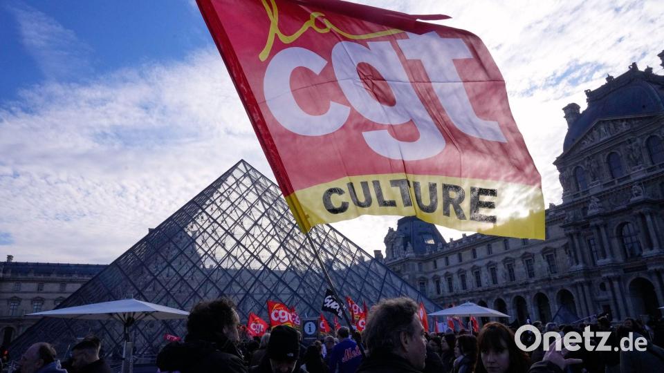 Angestellte zeigen eine Flagge der Gewerkschaft CGT vor dem Louvre, nachdem sie für einen Streik gestimmt haben. Bild: Michel Euler/AP/dpa