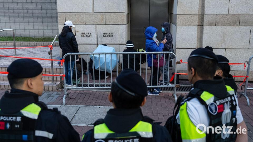 Menschen warten vor dem West Kowloon Magistrates' Courts auf die Urteilsverkündung gegen den Hongkonger Aktivisten und Verleger Jimmy Lai. Bild: Chan Long Hei/AP/dpa