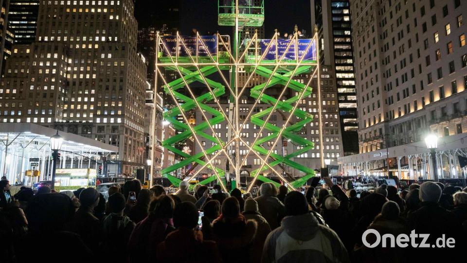 Menschen beobachten das Anzünden der weltgrößten Menora auf der Fifth Avenue. Bild: Yuki Iwamura/AP/dpa