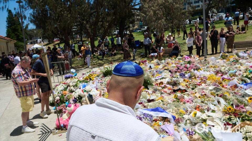 Menschen legen bei einer Gedenkfeier für die Opfer eines Terrorangriffs am Bondi Beach in Sydney Blumen nieder. (Foto aktuell) Bild: Flavio Brancaleone/AAP/dpa