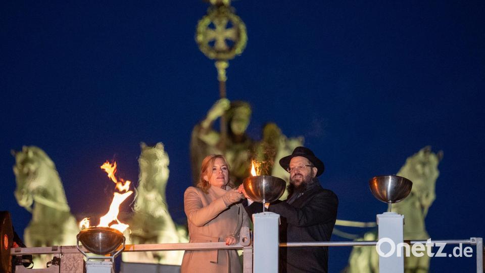 Bundestagspräsidentin Julia Klöckner (CDU) und Rabbiner Yehudi Teichtal entzünden am Brandenburger Tor während einer festlichen Zeremonie die Lichter am Chanukka-Leuchter mittels einer Fackel. Bild: Soeren Stache/dpa