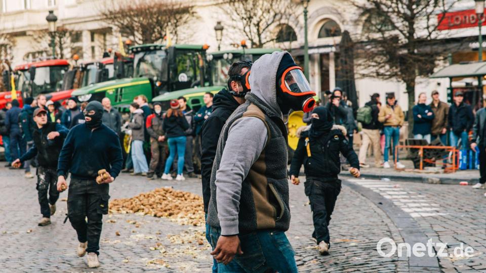 Maskierte Demonstranten stoßen mit der Polizei zusammen. Bild: Emile Windal/Belga/dpa