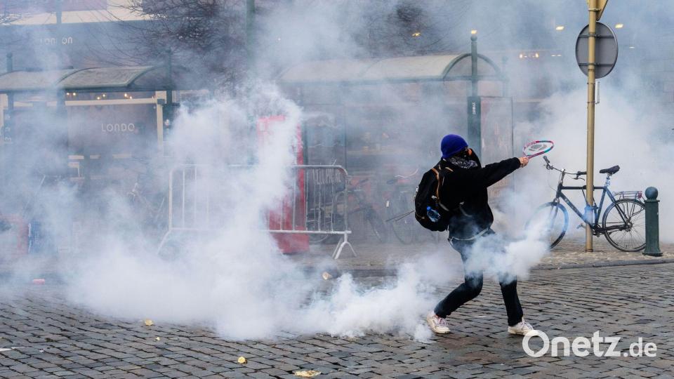 Ein Demonstrant schlägt bei den Protesten in Brüssel gegen einen Tränengasbehälter. Bild: Marius Burgelman/AP/dpa