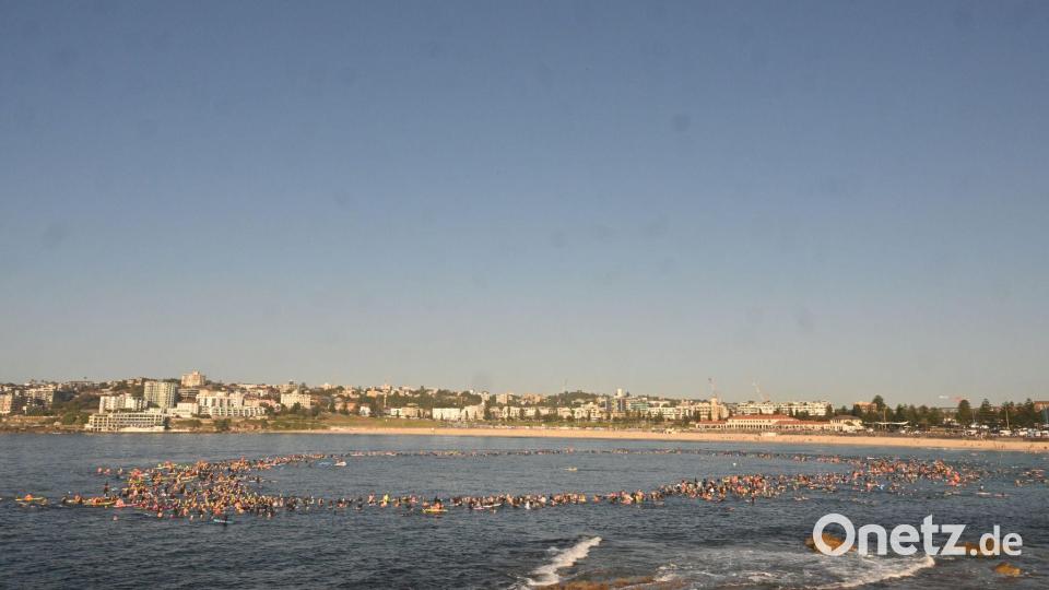 Surfer bildeten im Gedenken an die Anschlagsopfer einen Kreis im Meer. Bild: Mick Tsikas/AAP/dpa