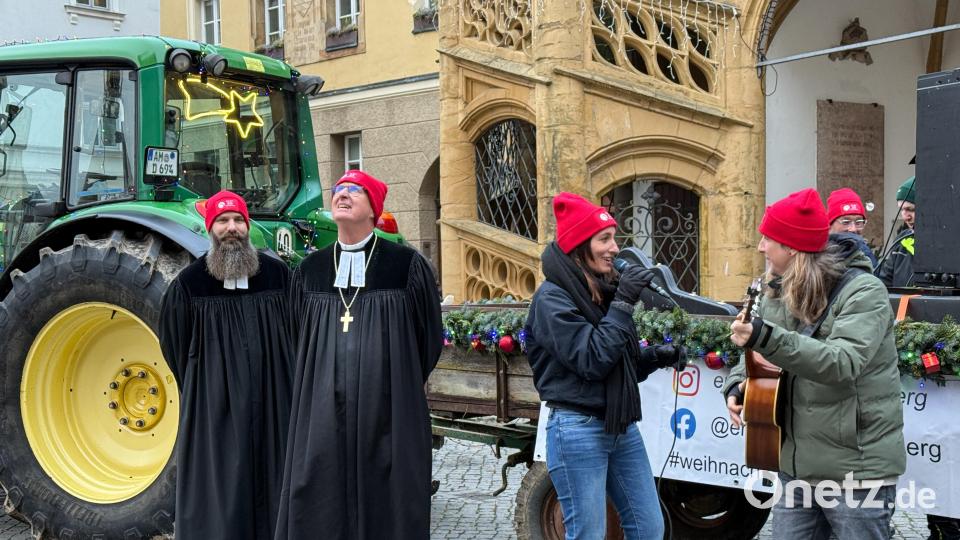 Während Diana Laden und Michael "Dandy" Dandorfer singen und spielen, schaut Regionalbischof Klaus Stiegler sinnend in den Himmel. Pfarrer David Scherf "bewacht" derweil den Weihnachtsbulldog der Erlösergemeinde. Bild: Petra Hartl