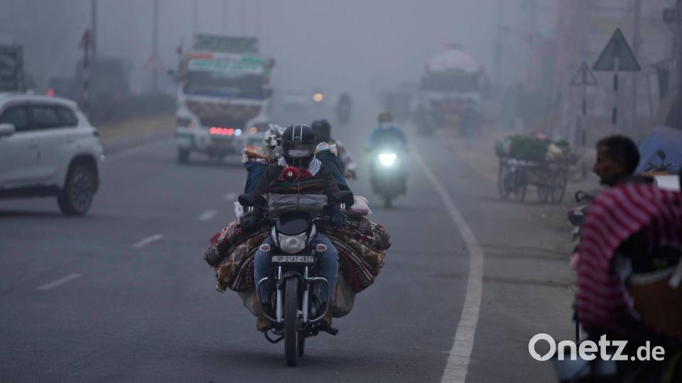 Trübe Sicht: Ein Händler transportiert seine Ware per Motorrad und fährt damit durch dichten Nebel im indischen Jammu. Bild: Channi Anand/AP/dpa