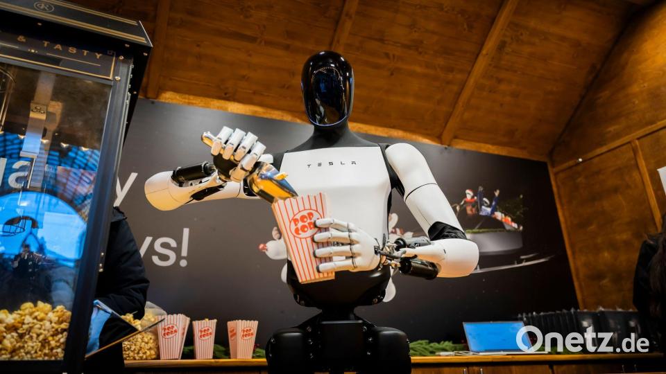 Der humanoide Roboter „Optimus“ von Tesla verteilt bei seiner Vorstellung in Berlin Popcorn. Bild: Christoph Soeder/dpa