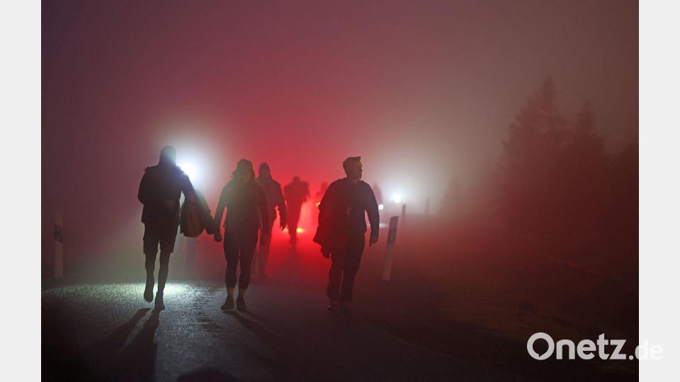 Geocacher kommen vor Sonnenaufgang auf den Brocken im Harz. Bild: Matthias Bein/dpa