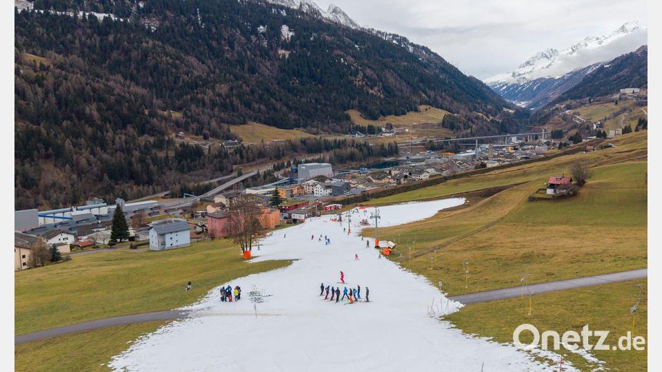Viel zu warm: Skifahrer fahren auf einer schmalen Piste aus Kunstschnee im Tessin in der Schweiz. Bild: Francesca Agosta/KEYSTONE/dpa