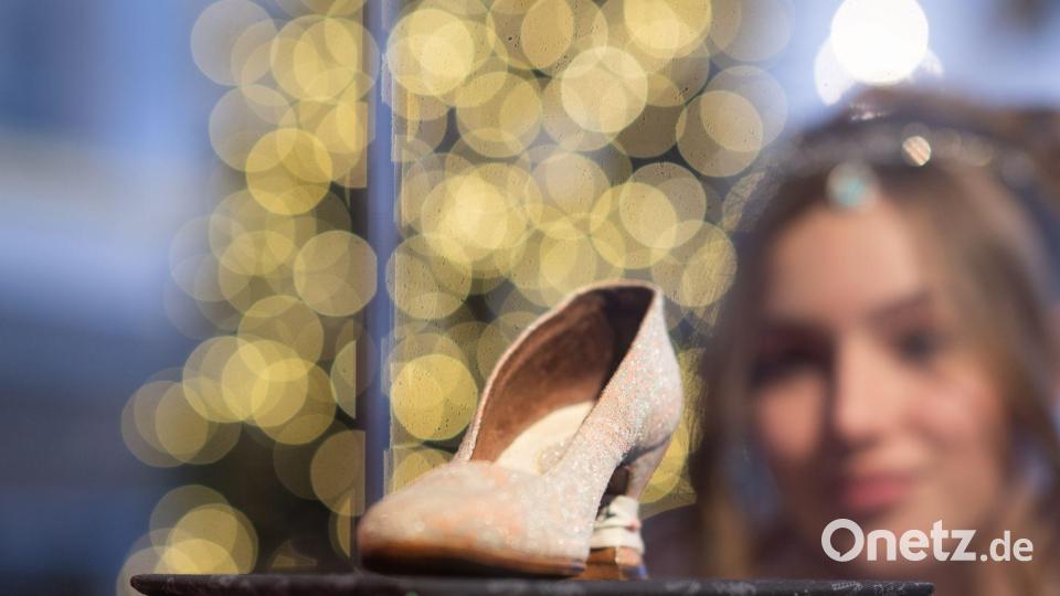 Tamara Kretschmer, Aschenbrödel des Schlüsselndes Sachsen, betrachtet im Festsaal von Schloss Moritzburg, dem einstigen Jagdschloss der Wettiner, vor der Eröffnung der traditionellen Winterausstellung „Drei Haselnüsse für Aschenbrödel“ zum gleichnamigen Kultfilm den originalen Tanzschuh. Die Präsentation macht bis zum 25. Februar 2024 die Welt rund um den bekannten Märchenfilm erlebbar. (Archivbild) Bild: Robert Michael/dpa