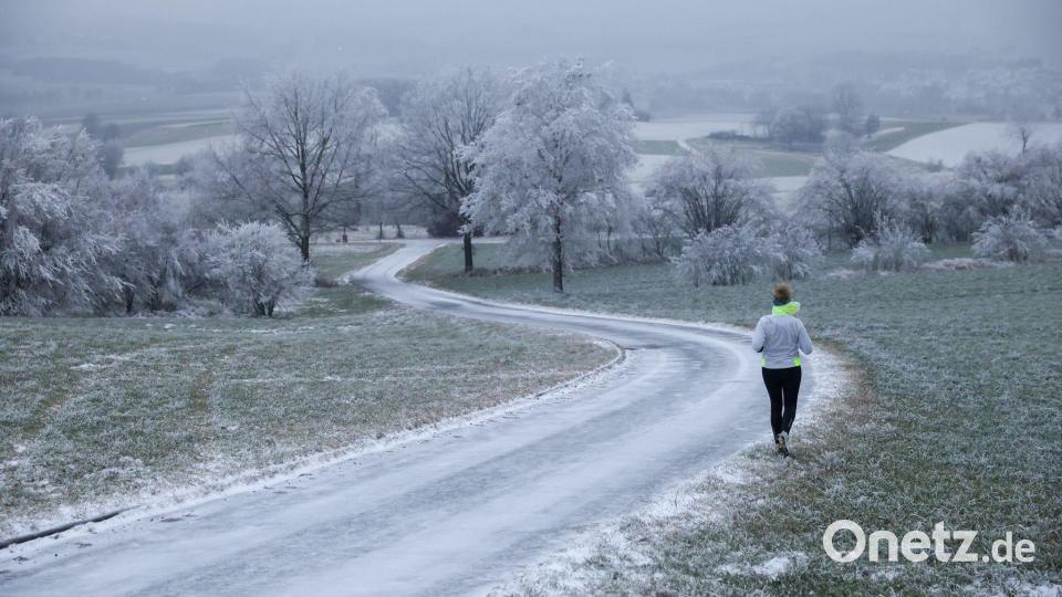 Joggerin trotzt Schnee und Raureif an Heiligabend in Uttenweiler Bild: Thomas Warnack/dpa