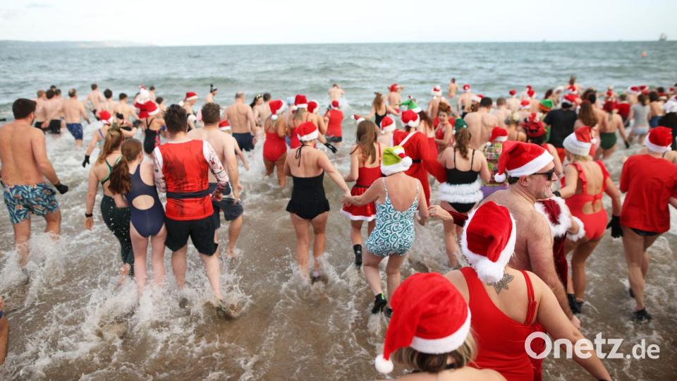 In der Helen's Bay in Nordirland schwimmen Menschen an Heiligabend im kalten Wasser des Belfast Lough, um Geld für Dementia NI und Air Ambulance NI zu sammeln. Bild: Peter Morrison/AP/dpa